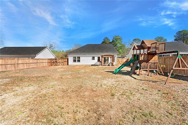 back of property featuring a fenced backyard and a playground