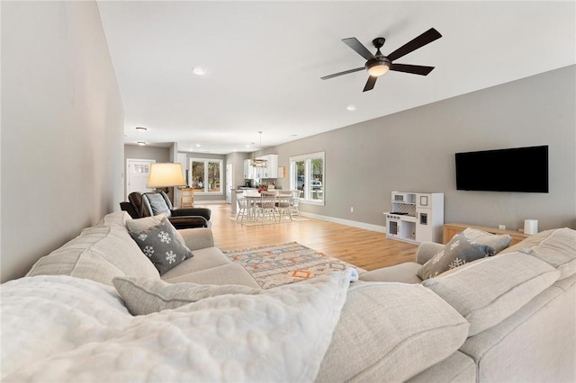 living area with light wood finished floors, baseboards, a ceiling fan, and recessed lighting