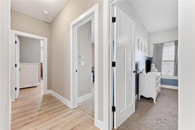 hallway with light wood finished floors and baseboards