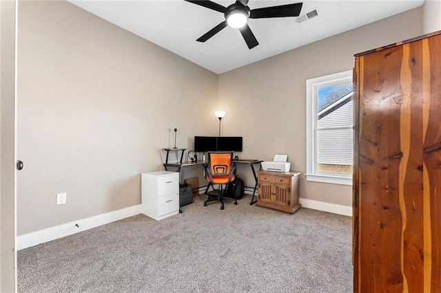 carpeted office space featuring a ceiling fan, visible vents, and baseboards