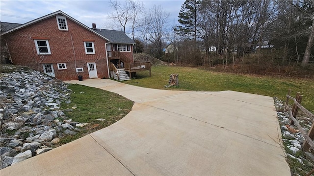 view of side of home featuring brick siding and a yard