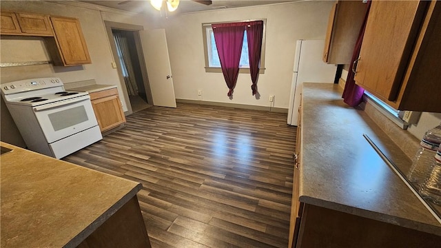 kitchen featuring dark wood-style floors, white appliances, a ceiling fan, and baseboards