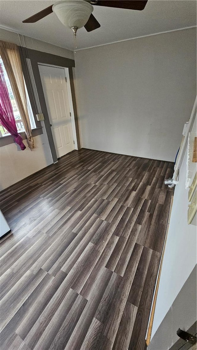 interior space with ceiling fan and dark wood-type flooring