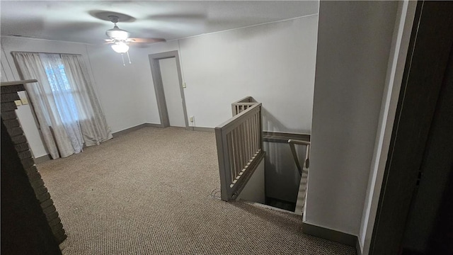 corridor featuring baseboards, carpet flooring, and an upstairs landing