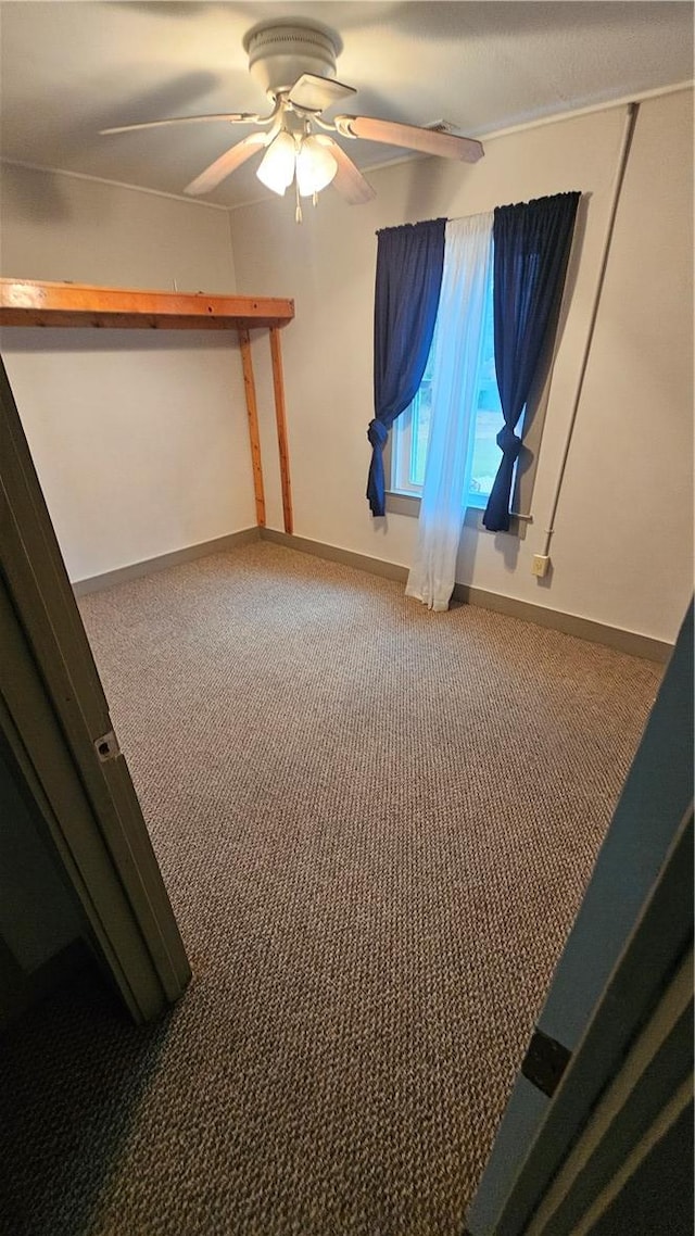 unfurnished bedroom featuring a ceiling fan, carpet, and baseboards