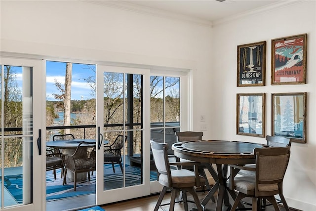 dining room with wood finished floors and crown molding