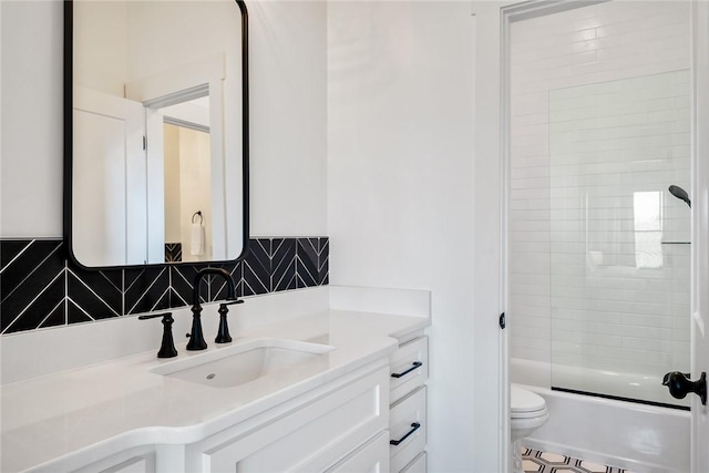 bathroom with enclosed tub / shower combo, tasteful backsplash, vanity, and toilet