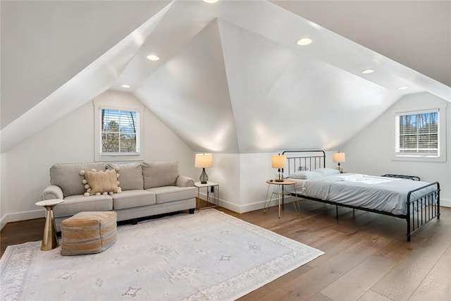 bedroom with vaulted ceiling, baseboards, and wood finished floors