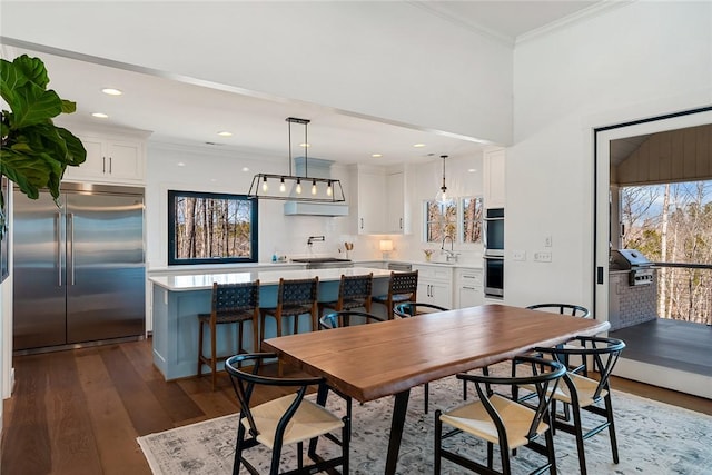 dining room with ornamental molding, recessed lighting, and dark wood-style flooring