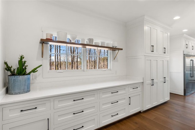 interior details with built in fridge, recessed lighting, ornamental molding, and wood finished floors