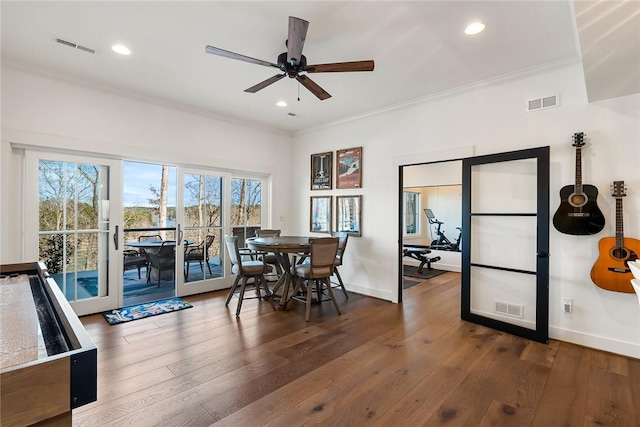 dining room featuring ornamental molding, visible vents, and hardwood / wood-style flooring