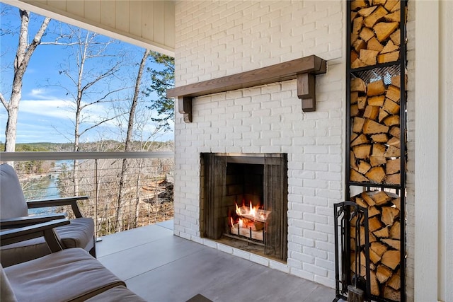 exterior space with an outdoor brick fireplace and brick siding