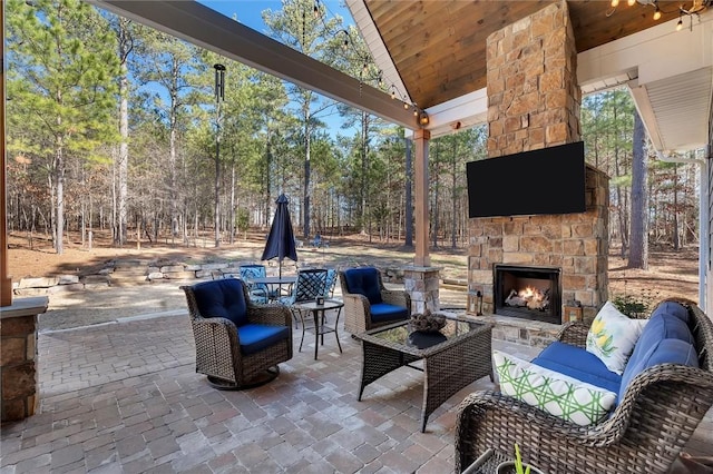 view of patio with an outdoor living space with a fireplace