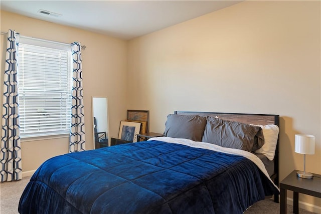 bedroom with carpet floors, baseboards, multiple windows, and visible vents