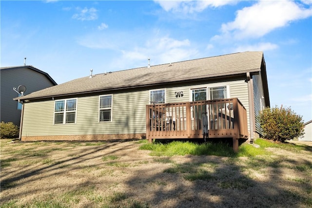 rear view of house with a lawn and a wooden deck