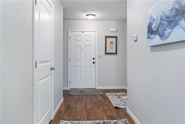 doorway to outside featuring visible vents, baseboards, and wood finished floors