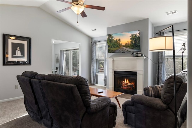 living room with a glass covered fireplace, carpet flooring, visible vents, and a healthy amount of sunlight