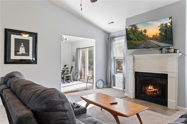 carpeted living room featuring a lit fireplace, visible vents, vaulted ceiling, and baseboards