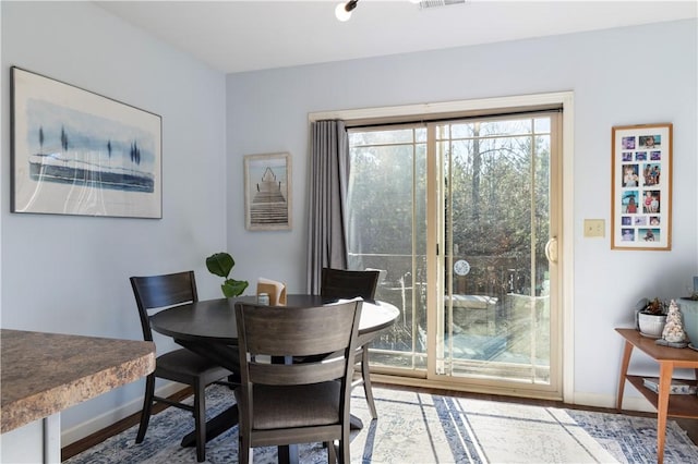 dining area with baseboards and wood finished floors