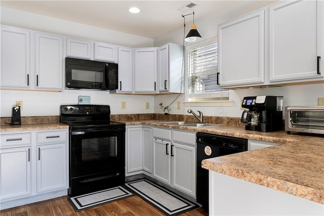 kitchen featuring a toaster, dark wood-type flooring, black appliances, a sink, and recessed lighting