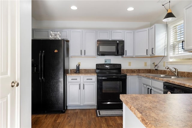 kitchen featuring dark wood finished floors, a sink, black appliances, and recessed lighting