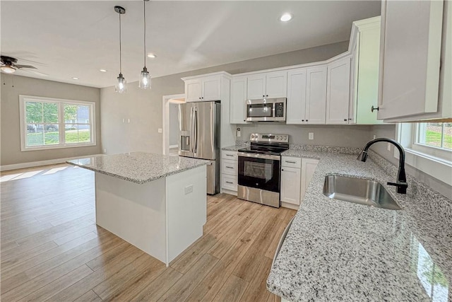 224 Simpson St, Westminster, SC 29693 - kitchen featuring appliances with stainless steel finishes, a ceiling fan, a kitchen island, decorative light fixtures, and light wood-style floors