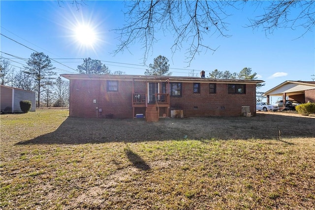 rear view of property featuring crawl space, a chimney, a lawn, and brick siding