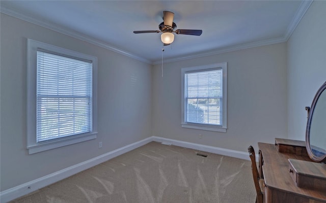 unfurnished office featuring visible vents, a ceiling fan, baseboards, ornamental molding, and carpet