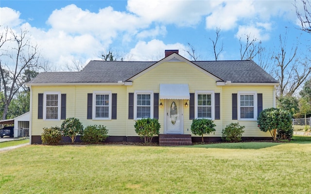 view of front of property with a shingled roof, a chimney, and a front lawn