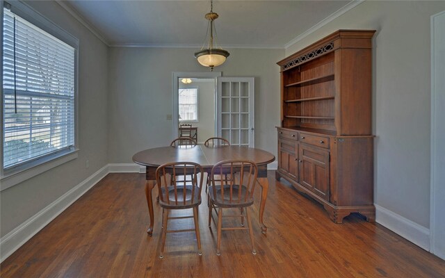 dining room with crown molding, dark wood finished floors, and baseboards