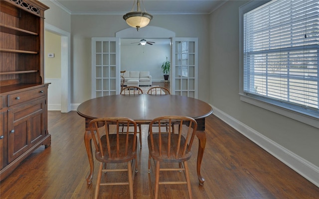 dining space featuring baseboards, a ceiling fan, dark wood-style floors, crown molding, and french doors