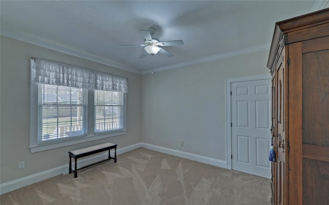 spare room with light carpet, crown molding, and baseboards