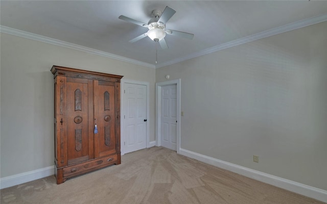 unfurnished bedroom featuring light carpet, baseboards, a ceiling fan, and ornamental molding