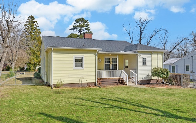 rear view of house with a yard, roof with shingles, fence, and a chimney