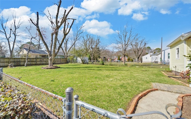 view of yard featuring a fenced backyard and a residential view