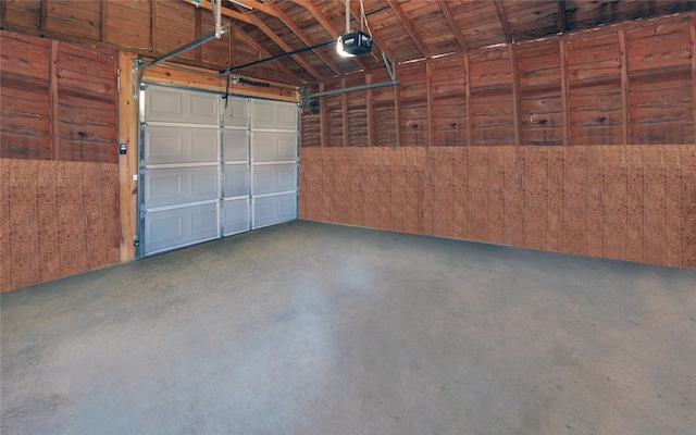 garage featuring wooden walls and a garage door opener