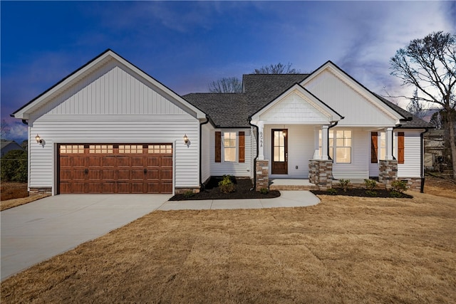 view of front facade with a garage, roof with shingles, driveway, and a lawn