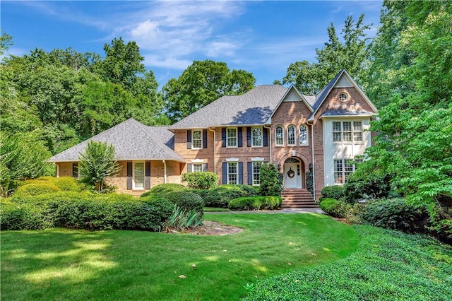 view of front of house featuring a front lawn and brick siding