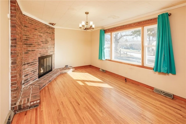 unfurnished living room with visible vents, crown molding, a fireplace, and wood finished floors