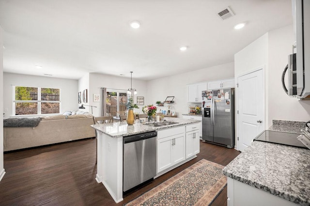 kitchen featuring appliances with stainless steel finishes, a kitchen island, visible vents, and white cabinets