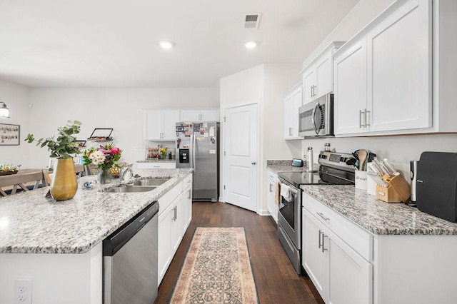 kitchen featuring visible vents, dark wood finished floors, appliances with stainless steel finishes, white cabinetry, and a sink