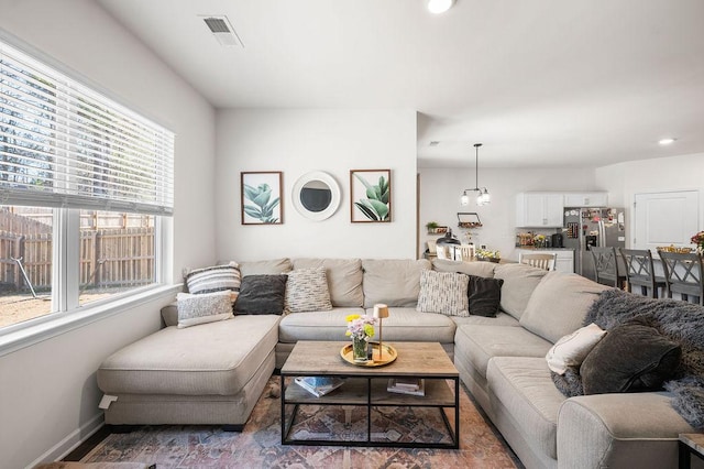 living room featuring an inviting chandelier, baseboards, and visible vents