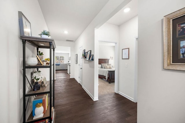 corridor featuring recessed lighting, dark wood-style flooring, visible vents, and baseboards