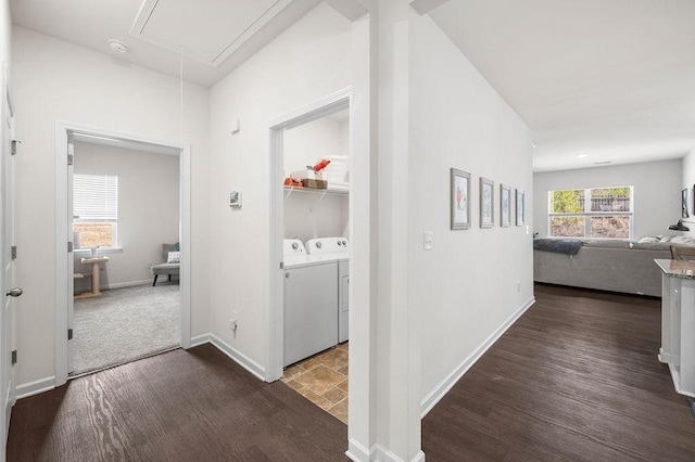 hall with attic access, dark wood-style flooring, baseboards, and separate washer and dryer