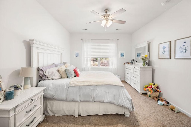 bedroom with light carpet, ceiling fan, visible vents, and baseboards