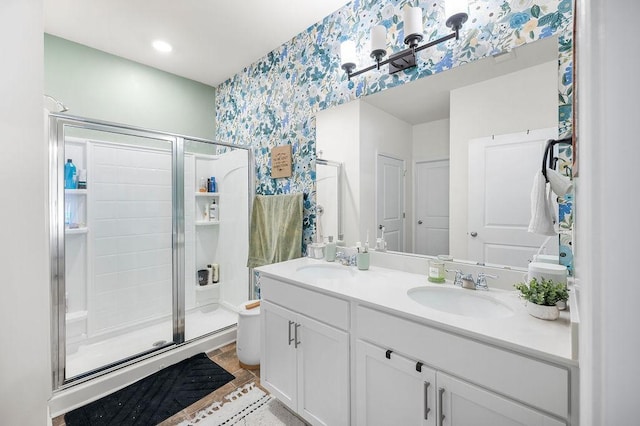 bathroom with double vanity, a sink, and a shower stall