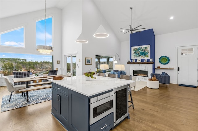1230 Melton Rd Unit 215, West Union, SC 29696 - kitchen featuring wood finished floors, stainless steel microwave, a large fireplace, ceiling fan, and high vaulted ceiling