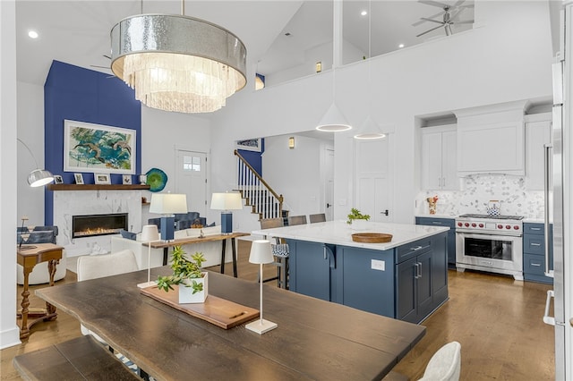 1230 Melton Rd Unit 215, West Union, SC 29696 - dining room with stairs, a fireplace, a towering ceiling, wood finished floors, and ceiling fan with notable chandelier