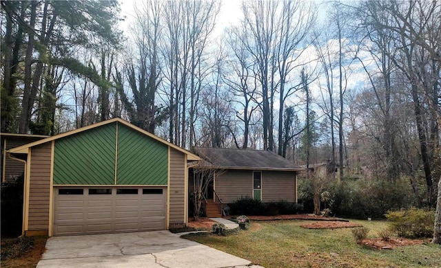 view of front of house with concrete driveway and a front lawn