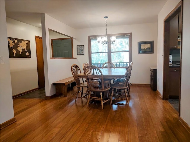 dining room featuring baseboards, a chandelier, and hardwood / wood-style floors